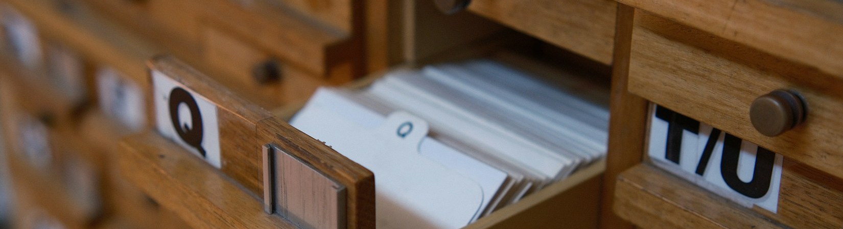 An open drawer of a wooden library card catalogue